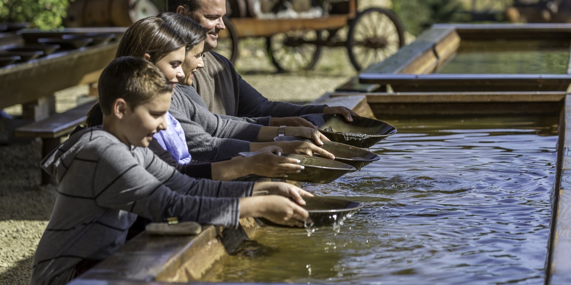 Family pans for gold in a trough
