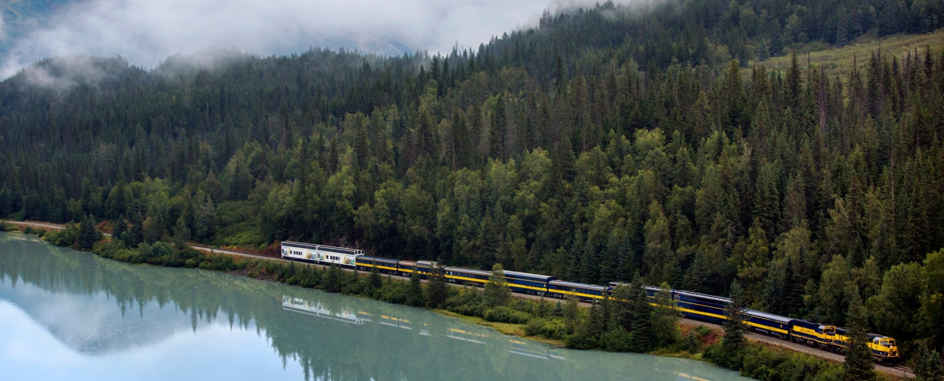 Train riding along the water