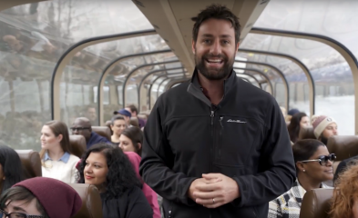 photo of man standing and people sitting on train